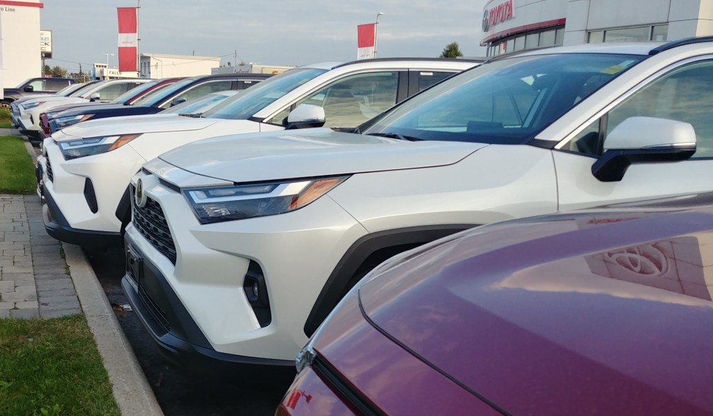 Toyota vehicles line the exterior of a dealership.