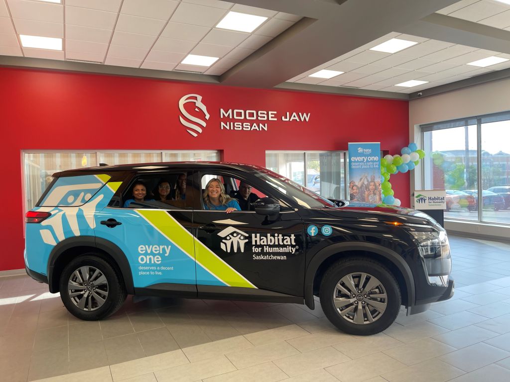 Nissan Pathfinder with Habitat for Humanity Saskatchewan decals and people inside