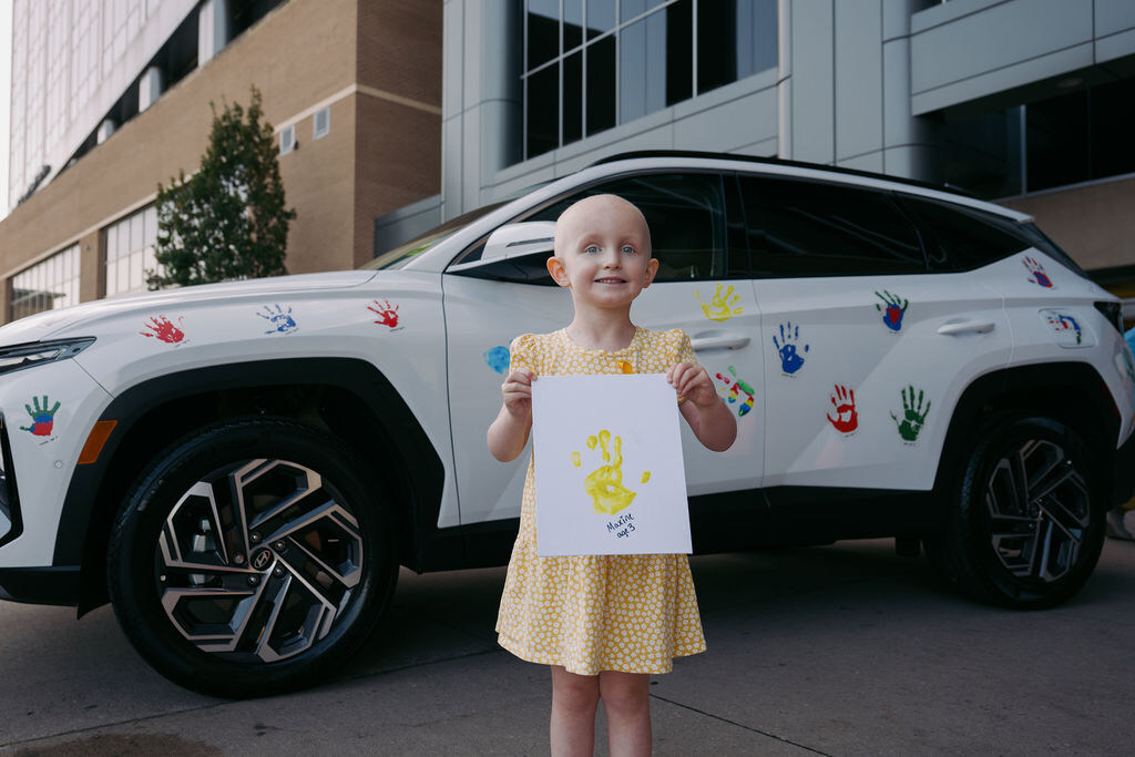 Child with hand print in front of Hyundai vehicle