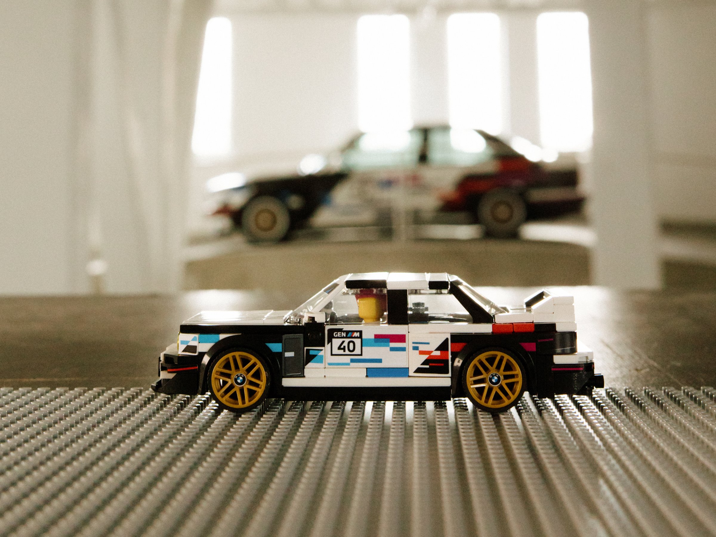 Lego Speed Champions BMW M3 E30 side, life-size car blurred in background