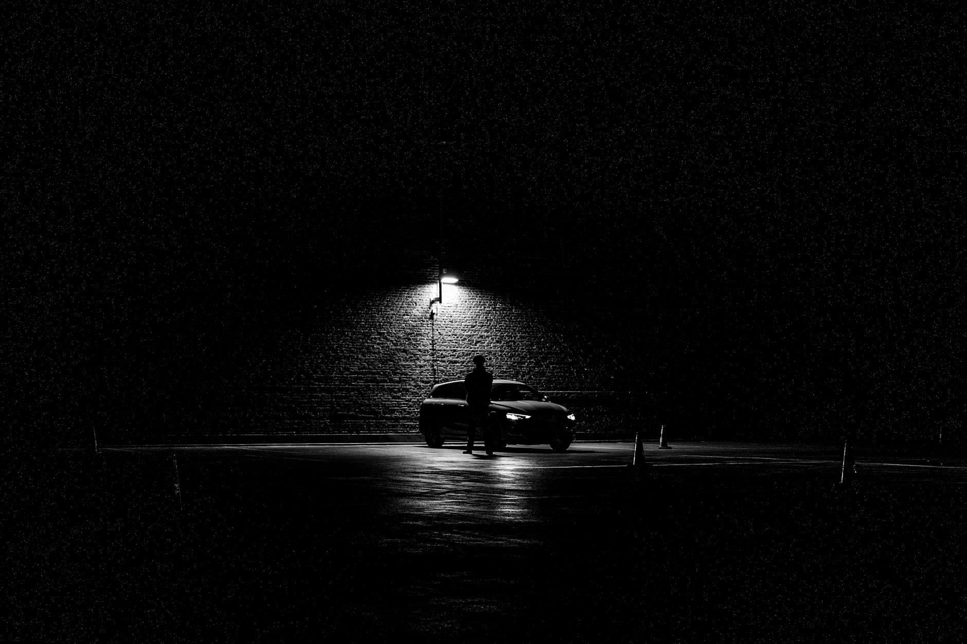 Lonely car and person in dark parking lot