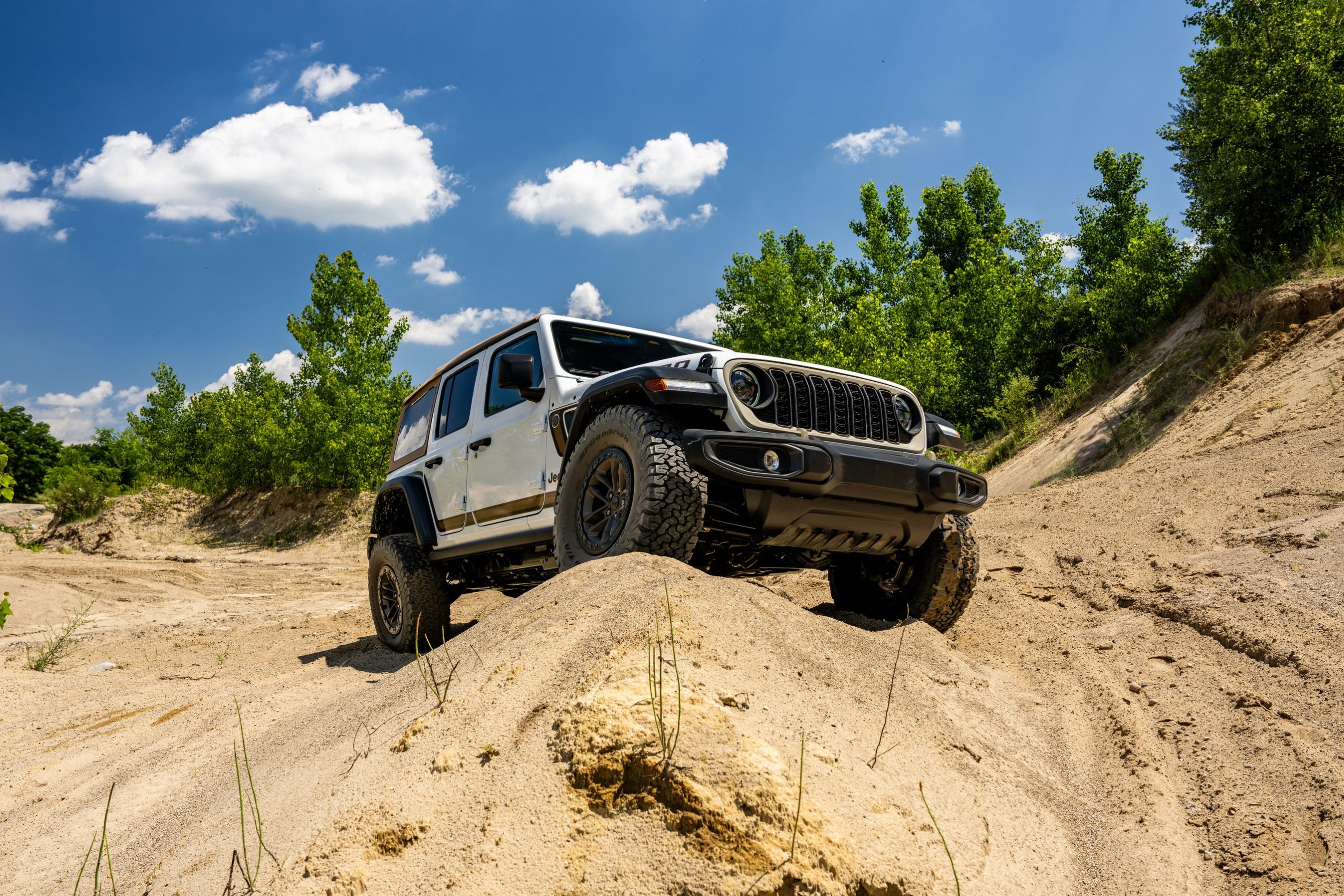 2027 Jeep Wrangler Laredo four-door driving up hill