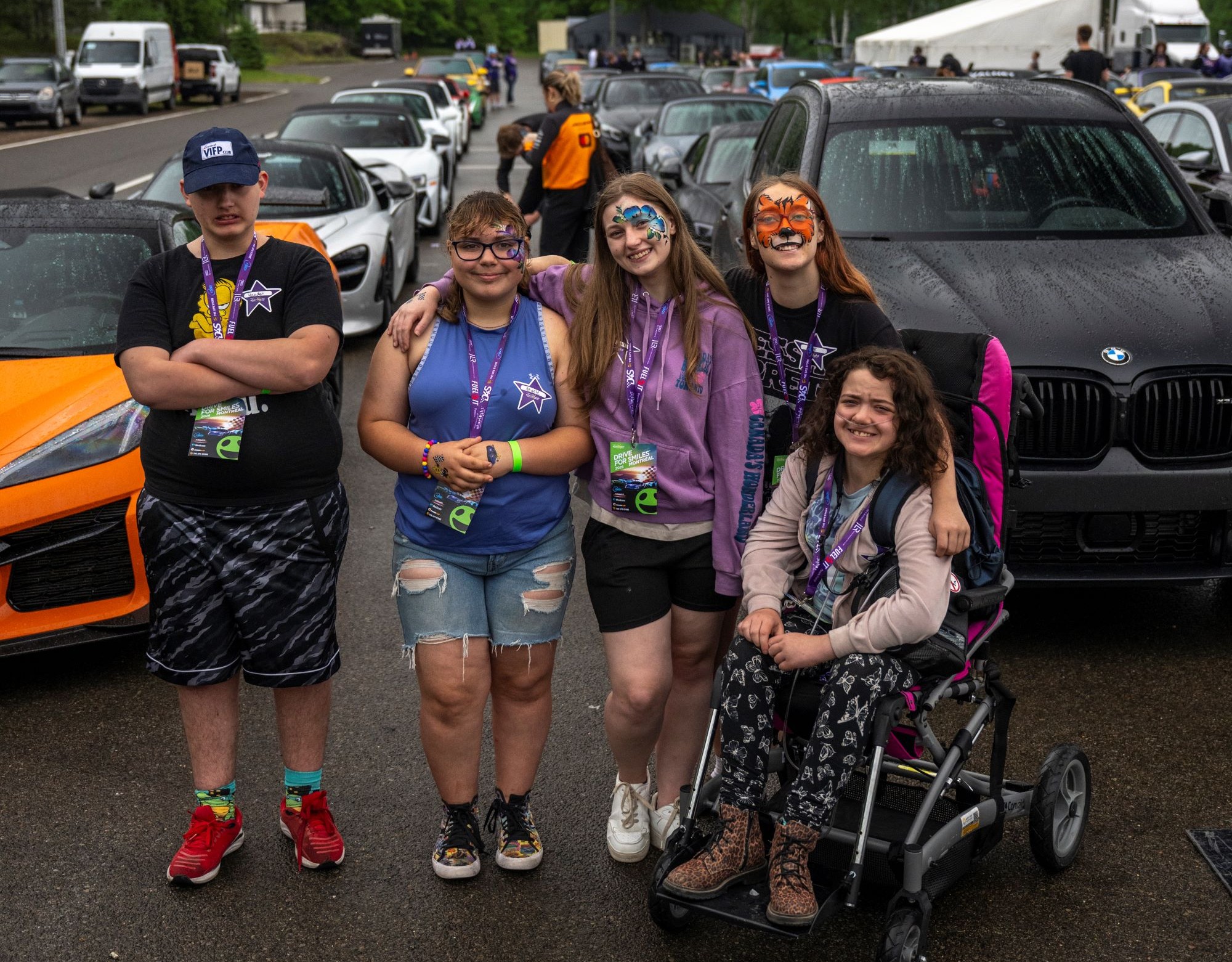 Children in front of high-end cars at Drive For Smiles Montreal