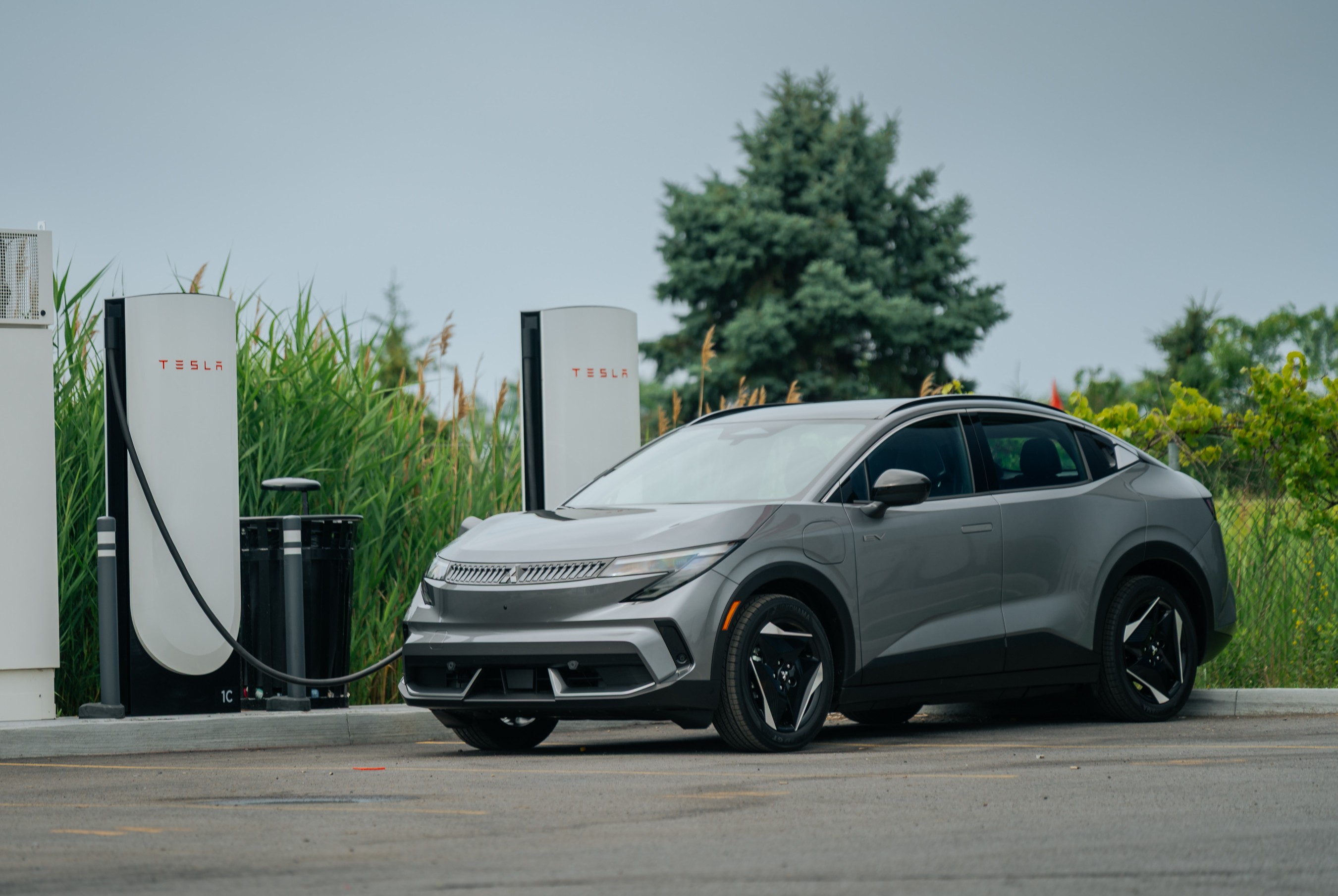 Mitsubishi Eclipse Sportback charging at Tesla Supercharger